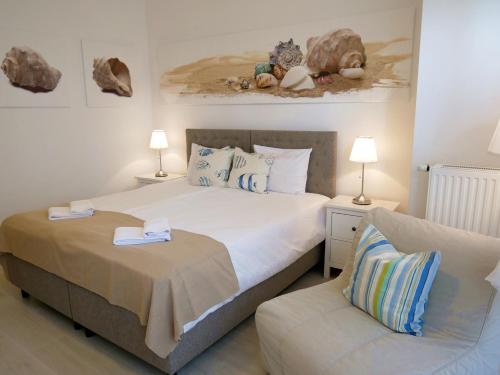シフィノウイシチェにあるTrzy Wyspy Apartments - Aquamarinaのベッドルーム(大型ベッド1台、ソファ付)