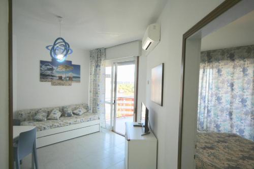 ein Wohnzimmer mit einem Sofa und einem Fenster in der Unterkunft BA - Cristallo - Sea View - in Lignano Sabbiadoro