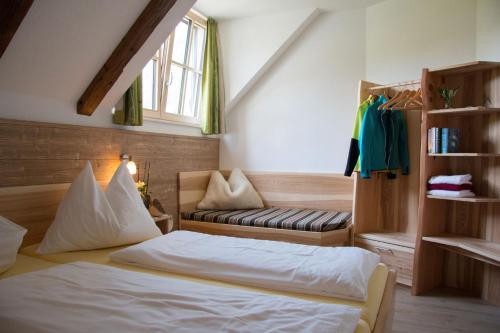 a bedroom with a bed and a couch and a window at Ferienhof Rinnergut in Hinterstoder