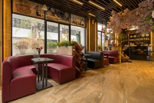 a restaurant with pink chairs and tables in a room at BBQ HOSTEL in Ha Long