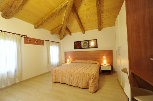 una camera con letto in una stanza con soffitti in legno di Terzo Bacino a San Michele al Tagliamento