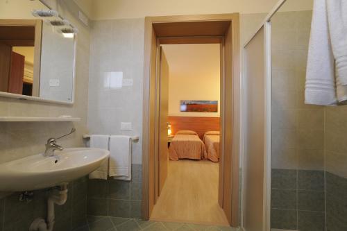 uma casa de banho com um lavatório e um chuveiro e um quarto em Terzo Bacino em San Michele al Tagliamento