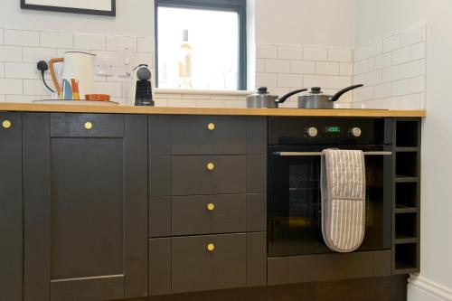 a kitchen with a counter with a stove and a sink at Nest House Super cosy one bedroom detached lodge center Huntingdon in Huntingdon