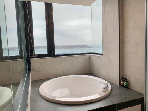 eine große Badewanne im Bad mit Fenster in der Unterkunft Dream Summer Hotel in Magong