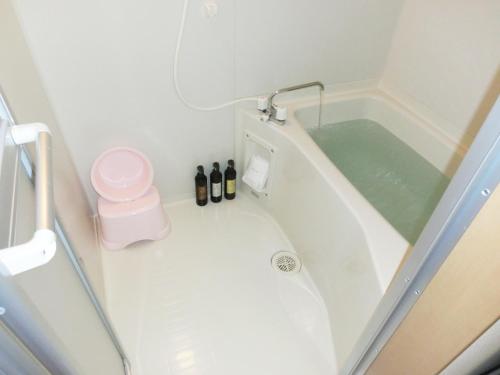 a small bathroom with a bath tub with bottles in it at BK Hotel & Weekly in Wakayama