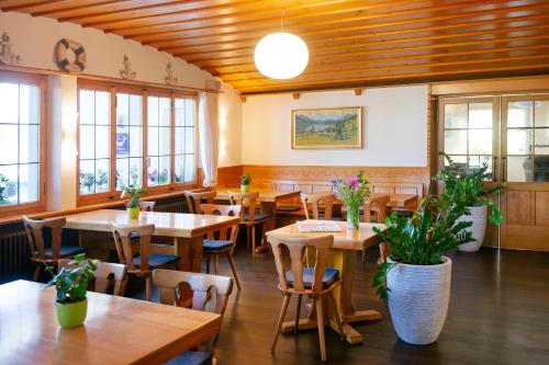a restaurant with wooden tables and chairs and windows at Landgasthof Zollhaus in Sachseln
