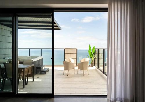 a balcony with a dining table and a view of the ocean at Oַ&O Group- Luxury Penthouse Jacuzzi Sea 36 Floor in Bat Yam
