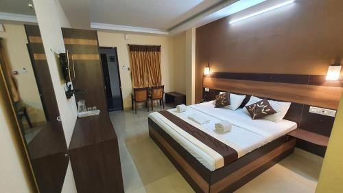 a bedroom with a large bed with a wooden headboard at S4 Residency in Chennai