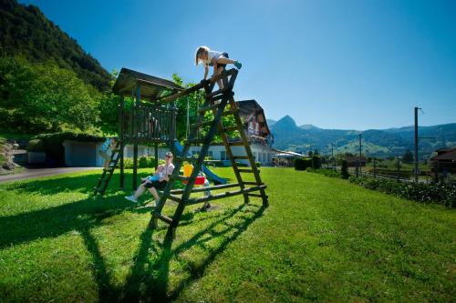 a woman is climbing up a ladder on a playground at Landgasthof Zollhaus in Sachseln