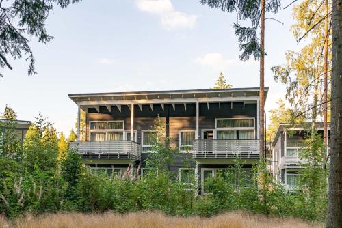 a house in the woods with trees at Saimaa Life Apartments in Imatra