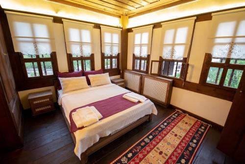 a bedroom with a bed in a room with windows at KÜRKÇÜ KONAK in Safranbolu