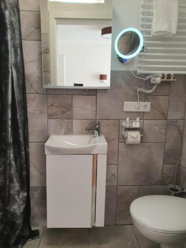 a bathroom with a toilet and a sink and a mirror at Nordsee-Pension Dagebüll in Dagebüll