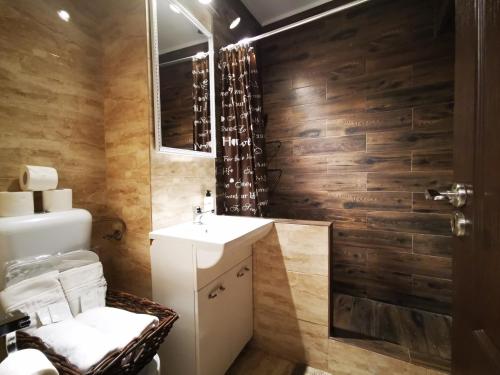 ブカレストにあるSudului 810 by MRG Apartments - Spitalul Bagdasar - Spitalul Obregiaのバスルーム(木製の壁、シンク、鏡付)