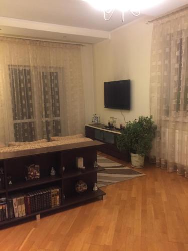 sala de estar con TV de pantalla plana y mesa en Apartments in a private house en Ivano-Frankivsk