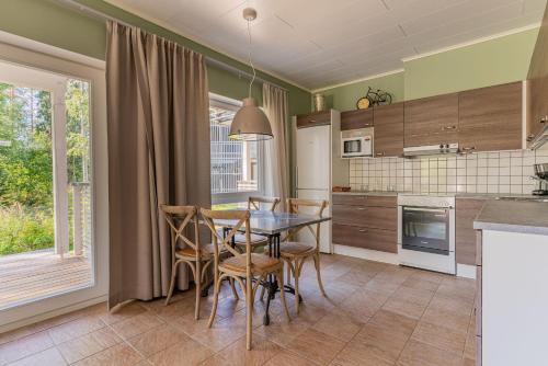a kitchen with a dining room table and chairs at Saimaa Life Apartments in Imatra