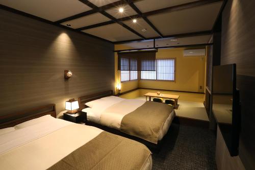 金沢市にある花明かりのベッド2台とテレビが備わるホテルルームです。