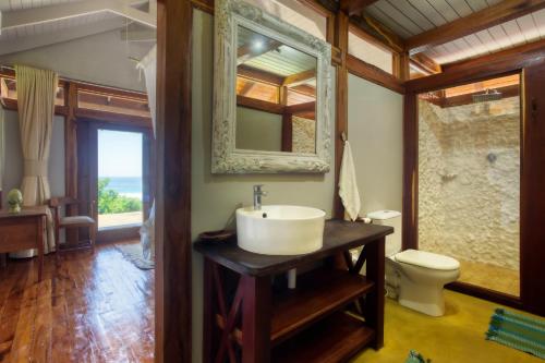a bathroom with a sink and a toilet at Aloha 6 in Ponta Mamoli