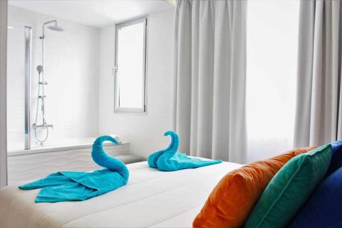 zwei blaue Schwäne auf einem Bett in einem Zimmer in der Unterkunft Ocean Garden Suite 12 in Adeje