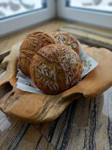 three loaves of bread sitting on a wooden plate at Appartement Winteraugut in Werfen