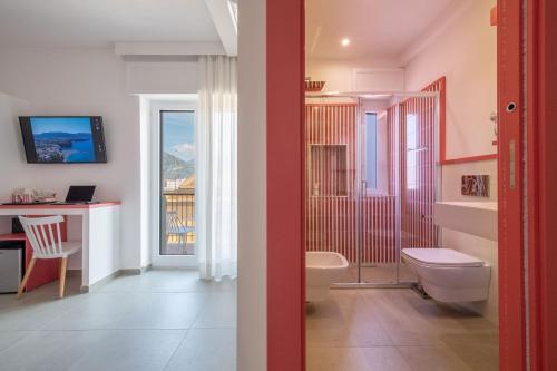 baño con aseo, escritorio y ventana en Al Campanile en Sant'Agnello