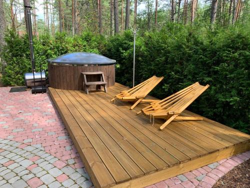 a wooden deck with two chairs and a gazebo at Okka Holiday Home in Alajõe