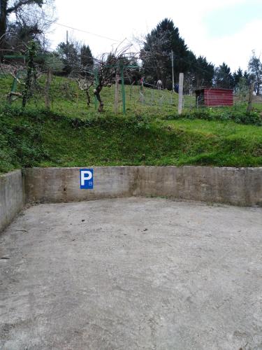 a parking lot with a parking sign on a wall at ANTZOMENDI in Mutriku