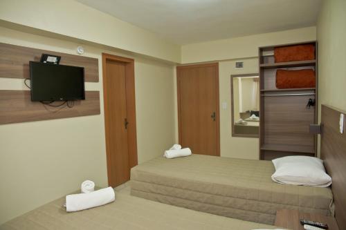 Dormitorio pequeño con cama y TV en Wallér Hotel & Eventos Inn Lajeado, en Lajeado