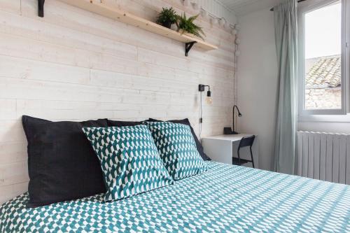 ein Schlafzimmer mit einem Bett mit zwei Kissen in der Unterkunft Le RI-BELLOT de 1 à 4 pers - Lit King Size in Cognac