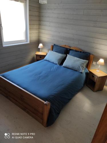 クソンリュプト・ロンジュメールにあるchalet des pierres opalinesのベッドルーム1室(青いシーツとテーブル2台付)