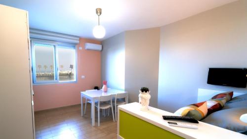 a small room with a bed and a table and a desk at La Palma Del Sol in Barletta