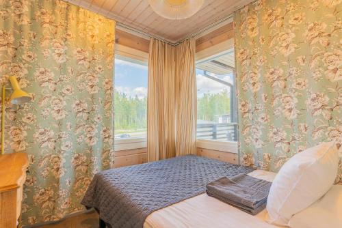 a bedroom with a bed in front of a window at Saimaa Life Apartments in Imatra