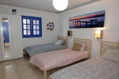 a bedroom with two beds and a painting on the wall at Casa con piscina privada en Cercados de Espino in Las Casillas