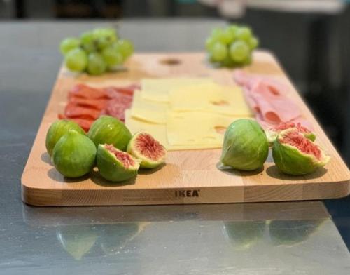 a cutting board with green peppers and meat and cheese at Apartments and pansion M&R in Turanj