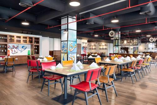 a restaurant with tables and chairs in a room at Wyndham Garden Muscat Al Khuwair in Muscat