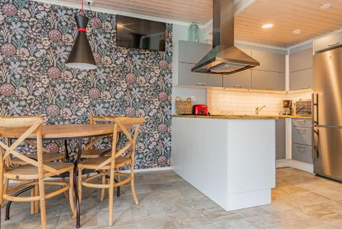a kitchen with a table and chairs and a refrigerator at Saimaa Life Apartments in Imatra