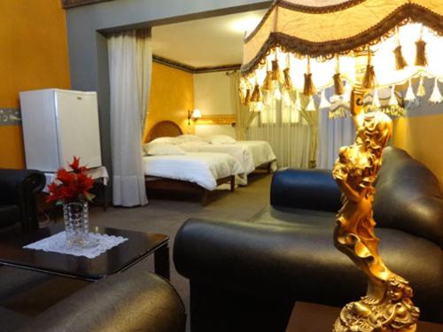 ポトシにあるCerro Ricoのベッド2台とリビングルームが備わるホテルルームです。