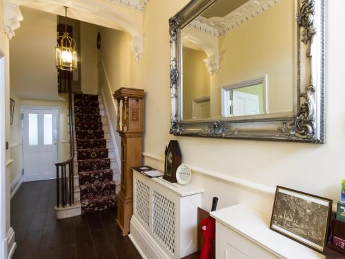 a hallway with a mirror and a staircase at The Portland Guesthouse in Cheltenham