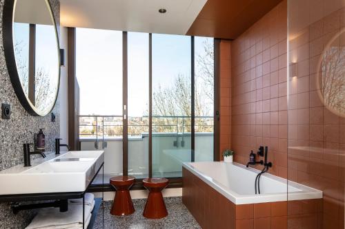 a bathroom with two sinks and a bathtub at Hôtel du Port in Nogent-sur-Marne