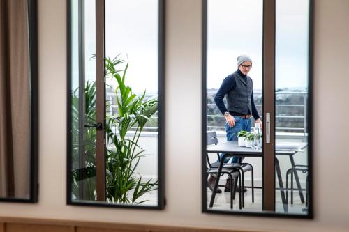 a man standing at a table in a room at Hôtel du Port in Nogent-sur-Marne