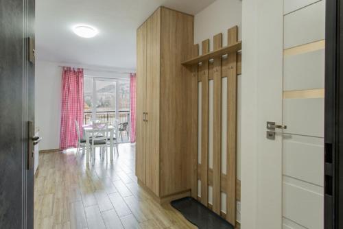 pasillo con puerta de madera y comedor en K2 Apartamenty en Karpacz