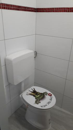 ein Badezimmer mit einem WC mit einem Frosch auf dem Deckel in der Unterkunft Emi in Klagenfurt am Wörthersee