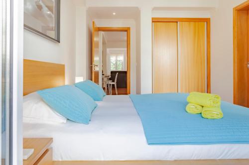 1 dormitorio con 1 cama grande con almohadas azules y amarillas en Capuchinhas Apartment, en Funchal