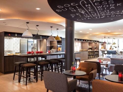 a restaurant with tables and chairs and a bar at ibis Amsterdam Centre Stopera in Amsterdam