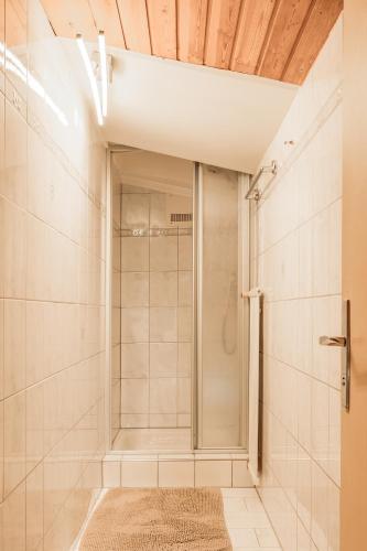a shower with a glass door in a bathroom at Fortuna Apart Hotel B&B in Ischgl