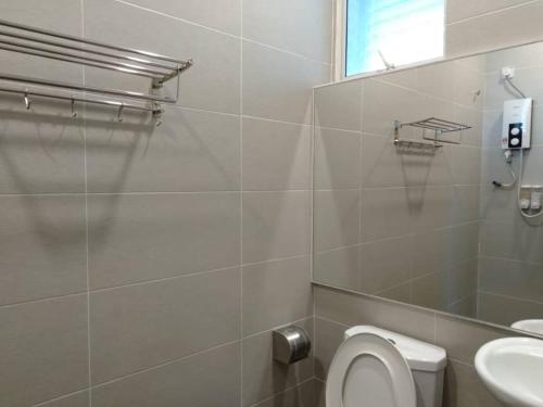 a bathroom with a toilet and a sink and a mirror at MD Boutique Hotel in Kampar
