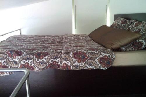 een bed met een deken en een kussen erop bij L'Annexe in Menton