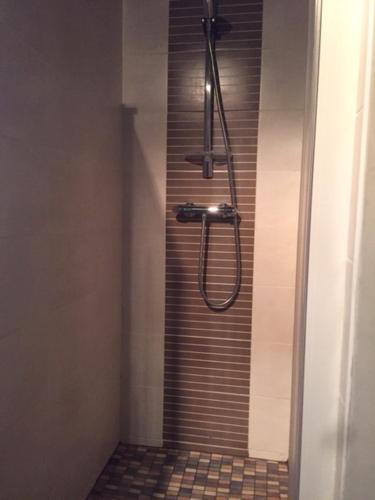 La salle de bains est pourvue d'une douche et de carrelage. dans l'établissement Gite Le Grand Manoir, à Servon