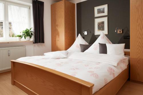 sypialnia z dużym łóżkiem z białą pościelą i poduszkami w obiekcie Ferienwohnung Ebert w mieście Oberstdorf