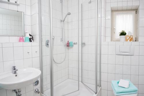 een witte badkamer met een douche en een wastafel bij Ferienwohnung Ebert in Oberstdorf