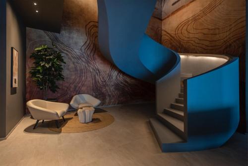 a lobby with a staircase and a chair and a stair case at EALA My Lakeside Dream - Adults Friendly in Limone sul Garda